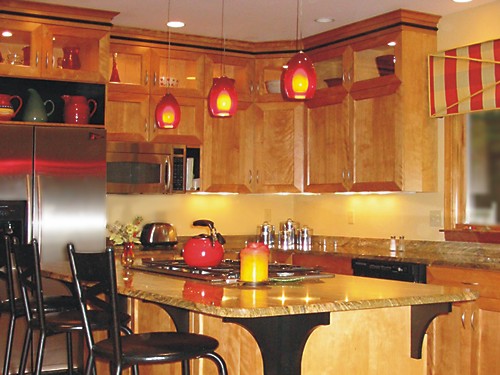 This homeowner wanted a punch of color and accomplished it with red pendant lighting and red accessories such as the teapot and displayed glassware.